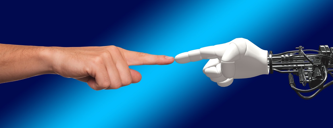 A hand pointing at a robotic hand that is pointing back.